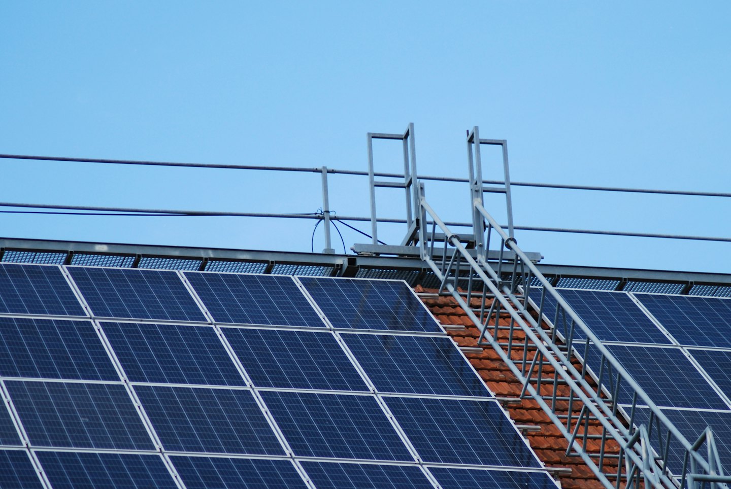 Dark blue solar panels on a terracotta tiled roof.